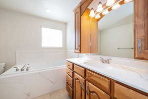 Primary full bath with a garden tub and vanity