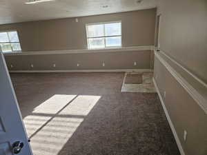 Unfurnished room featuring baseboards, carpet, and a healthy amount of sunlight