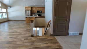 Kitchen with stainless steel appliances, a sink, baseboards, light wood-type flooring, and recessed lighting