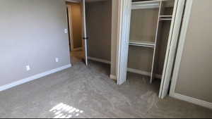 Unfurnished bedroom featuring carpet, a closet, and baseboards