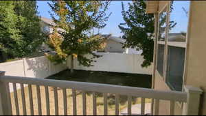 View of yard with fence and a balcony