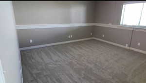 Carpeted spare room with baseboards