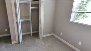 Unfurnished bedroom with a closet, carpet flooring, and baseboards