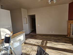 Living room with wood finished floors, a ceiling fan, and baseboards
