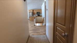 Hall featuring an upstairs landing, a sink, baseboards, and recessed lighting