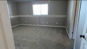 Carpeted empty room featuring baseboards