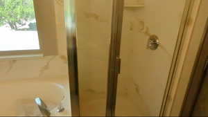 Bathroom featuring a shower stall and a bath