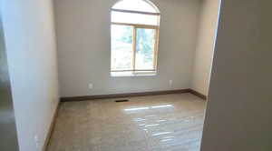 Carpeted spare room with baseboards