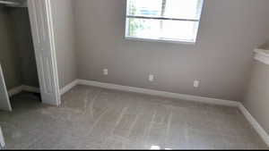 Unfurnished bedroom featuring carpet and baseboards