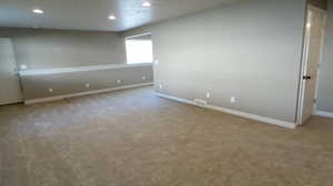 Carpeted spare room featuring baseboards and recessed lighting