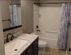 Full bath featuring toilet, shower / tub combo with curtain, and vanity