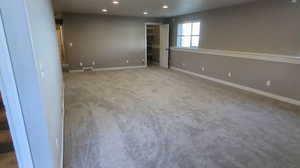Carpeted empty room featuring recessed lighting and baseboards