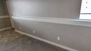 Carpeted empty room featuring baseboards