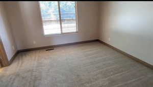 Unfurnished room with light carpet and baseboards