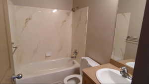 Bathroom featuring toilet, bathtub / shower combination, and vanity
