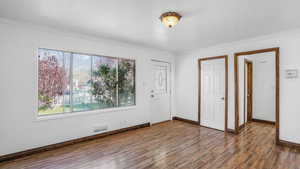 Unfurnished bedroom featuring wood finished floors, visible vents, crown molding, and multiple windows