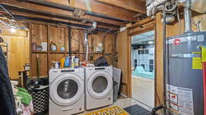 Laundry area featuring washing machine and dryer, gas water heater, and laundry area