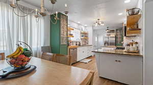 Dining room with a chandelier, light wood finished floors, and recessed lighting