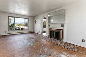 Unfurnished living room featuring a fireplace with flush hearth, a baseboard radiator, baseboards, and a textured ceiling