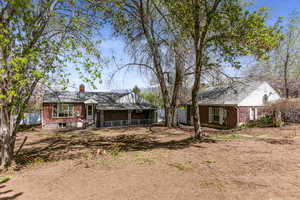 Rear view of property with fence, a chimney, and brick siding