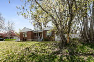 View of front featuring a front lawn, brick siding, and covered porch