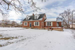 View of front of house with a chimney and brick siding