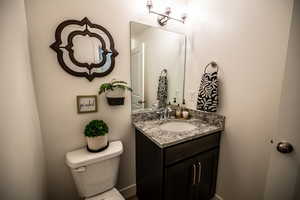 Half bath featuring toilet and vanity