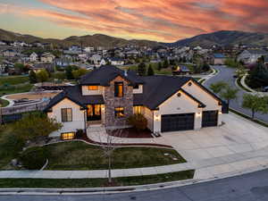 View of front of property featuring a residential view, driveway, stone siding, a mountain view, and a garage