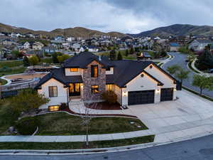 View of front facade featuring a residential view, a mountain view, stone siding, concrete driveway, and an attached garage