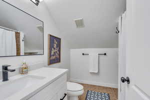 Bathroom featuring tile patterned flooring, visible vents, toilet, vanity, and baseboards