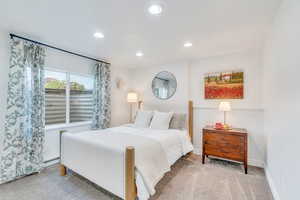 Carpeted bedroom featuring recessed lighting, baseboards, and a baseboard heating unit