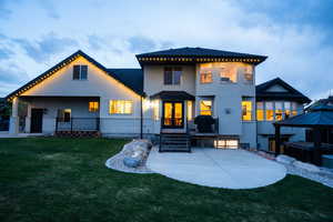 Back of property with a patio area, french doors, a yard, stucco siding, and brick siding