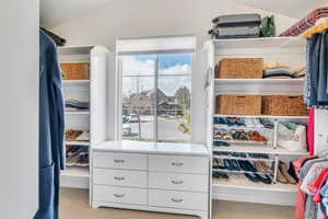 Spacious closet with lofted ceiling and carpet floors