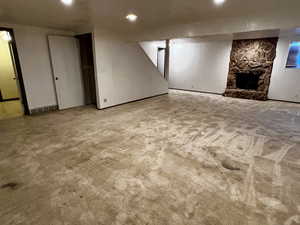 Finished basement featuring a fireplace, visible vents, carpet, and recessed lighting