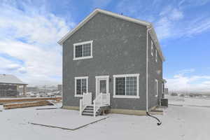 Back of property with stucco siding and central AC unit