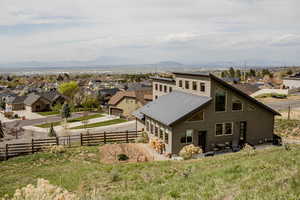 Rear view of house, from the back yard, Bonneville shoreline trail,  featuring metal roof, a residential view, fence, and a mountain view