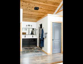 Large bathroom attached to main bedroom. baseboards, vaulted ceiling, and wooden ceiling