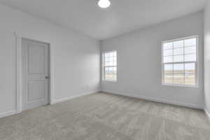 Carpeted spare room with baseboards