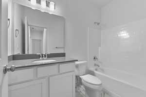 Full bath with shower / bathing tub combination, toilet, vanity, and marble finish floor