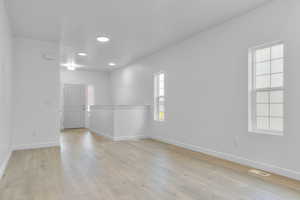 Spare room featuring baseboards, visible vents, and a wealth of natural light