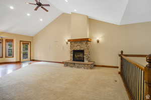 living room with recessed lighting, carpet, a stone fireplace, high vaulted ceiling, and ceiling fan