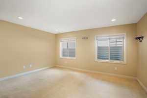 Spare room with recessed lighting, a wealth of natural light, baseboards, and light colored carpet