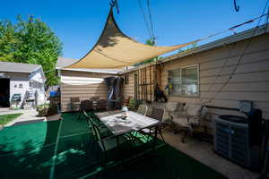 View of patio with an outdoor structure, central AC unit, and outdoor dining area