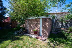 View of shed featuring a fenced backyard and a playground