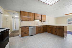 Kitchen featuring dishwasher, light countertops, electric stove, a peninsula, and baseboards