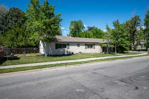 Ranch-style home featuring fence and a front lawn