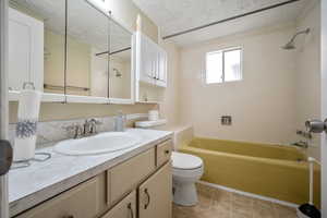 Full bath featuring vanity, shower / bathing tub combination, toilet, and a textured ceiling