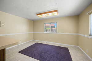 Spare room with baseboards and a textured ceiling
