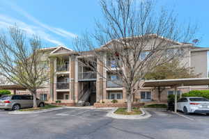 View of building exterior with covered and uncovered parking
