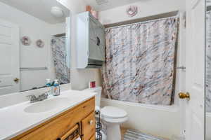 Bathroom featuring shower / tub combo, vanity, tile patterned flooring, and toilet